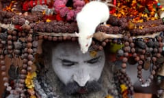 A Naga Sadhu or naked holy man with a white rat on his head sits in his tent during the Kumbh Mela in Allahabad, India.