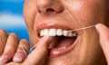 a close-up of a woman flossing her teeth