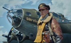 Austin Butler dressed as a second world war pilot standing beside a bomber aircraft.