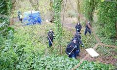 Police officers search through undergrowth with poles