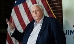 An older man in front of a US flag.