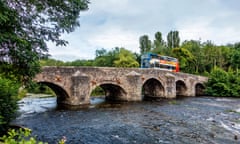 A double decker crosses Bickleigh Bridge over the River Exe.