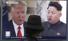 A man watches a television screen showing President Donald Trump and North Korean leader Kim Jong-un during a news programme at a train station in Seoul, South Korea