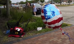 People check their belongings as a chair sits on the ground after a shooting at the Fourth of July parade in Highland Park, Illinois. 