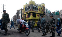Police patrol a road near a burnt-out building in a riot-affected area, in New Delhi, India, in March.