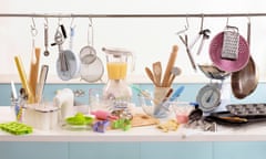 Various cooking and baking utensils on shelf and hanging from rail