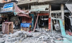 Shattered shop fronts littered with rubble and broken materials.