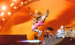 Flea, Red Hot Chili Peppers bass player, jumps into the air during performance