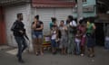 Um policial caminha residentes passado durante um confronto com traficantes de drogas, no Complexo do Alemão, Rio de Janeiro.