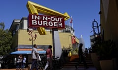 Pedestrians walk below an In-N-Out Burger restaurant sign in San Francisco, Thursday, Aug. 25, 2022. More than a half-million California fast food workers are pinning their hopes on a groundbreaking proposal that would give them increased power and protections. (AP Photo/Jeff Chiu)