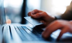 Man using laptop and holding credit card