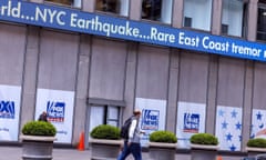 man walks past sign saying 'nyc earthquake'