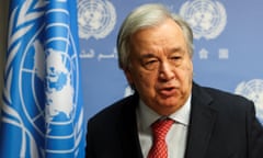 The United Nations secretary general, António Guterres, next to the UN flag