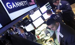 FILE - In this Aug. 5, 2014, file photo, specialist Michael Cacace, foreground right, works at the post that handles Gannett, on the floor of the New York Stock Exchange. USA Today owner Gannett announced Monday, May 16, 2016, that it is boosting its buyout offer for Tribune Publishing Co. as it continues its pursuit of the owner of the Los Angeles Times, Chicago Tribune and other newspapers. (AP Photo/Richard Drew, File)