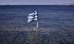 This photo taken on July 29, 2015 shows a Greek flag floating in the sea at the Kalamitsa beach on Skyros island. Greece expects debt reduction from its international creditors after a first assessment of reforms under its new bailout obligations concludes in November, Prime Minister Alexis Tsipras said on July 29. AFP PHOTO/ LOUISA GOULIAMAKILOUISA GOULIAMAKI/AFP/Getty Images