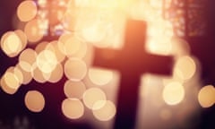 Defocussed cross silhouetted in church interior.