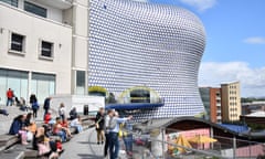 People sit outside the Bullring shopping centre in Birmingham.