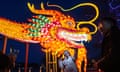 A woman takes a selfie as she and others gather in front of a large dragon figure in Beijing, China