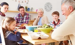 Multi-generation family eating lunch at kitchen table.