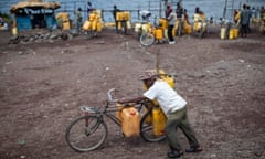 A man pushes his bike holding jerry cans with water taken from Lake Kivu on April 24, 2014 in Goma.