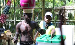 a man puts a voting ballot in a plastic tub in Bougainville