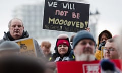 Protesters hold placards, one of which reads: 'We will not be mooooved. No farms, no future'