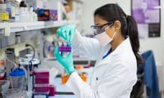 Closeup portrait, young scientist in labcoat wearing nitrile gloves, doing experiments in lab, academic sector.<br>EM277F Closeup portrait, young scientist in labcoat wearing nitrile gloves, doing experiments in lab, academic sector.