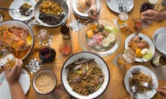 Taken from above, plates and bowls of food and glasses of beer from the predominantly meat-heavy menu at Isolina: Taberna Peruana restaurant in Lima, Peru.