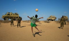 Ugandan soldiers deployed with AMISOM play football with Somali children after taking back a town from al-Shabab)