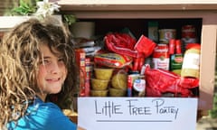 A young child stands in front of a free pantry.