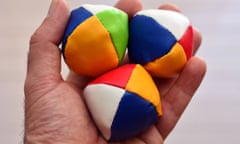 Man holds three (3) Juggling balls on one hand (left) against light background. concept photo, copy spaceE3YPH8 Man holds three (3) Juggling balls on one hand (left) against light background. concept photo, copy space