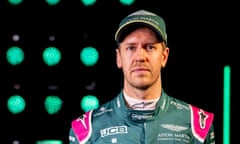 Ahead of shoulders shot of Sebastian Vettel looking at the camera in the green uniform and cap of Aston Martin