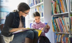 Mother and daughter reading book in bookstore