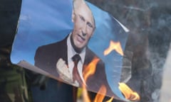 epa04643195 Activists burn a portrait of Russian President Vladimir Putin as they gathered to pay tribute to the memory of Boris Nemtsov in eastern Ukrainian city of Mariupol, Ukraine, 01 March 2015. Russian opposition leader Boris Nemtsov was shot dead from a passing car on the Bolshoy Kammeny bridge in central Moscow late in the evening of 27 February 2015.  EPA/SERGEY VAGANOV