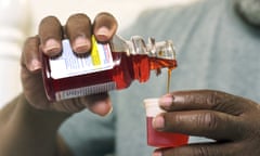 Man pouring medicine out of bottle, close-up