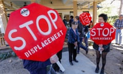 People holding up signs reading 'Stop Displacement'.