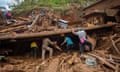 People search under the remains of a ceiling covered in mud and debris