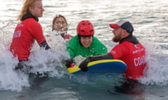 Sophie Elwes, a first-time surfer, is instructed by coaches whilst waiting for a wave.