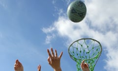 Hands reach up for a netball