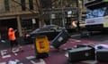 A construction worker throws garbage bins at a tram