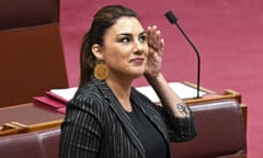 Lidia Thorpe in the Senate with a hand up to one side of her head