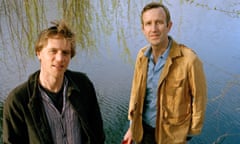 Johnny Flynn and Robert Macfarlane photographed from above, with a lake and the fronds of a willow behind them