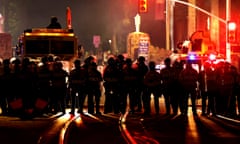 Police in armor block a road.