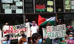 Students stand outside a building holding signs reading 'No more universities in Gaza' and 'LSE disclose invest'