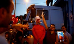 Man holding up noose around neck of effigy of cleric