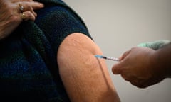UK Aims For 2 Million Vaccinations Per Week<br>LONDON, ENGLAND - JANUARY 07: Joan Worsfold receives the first of her two jabs of the Pfizer/BioNTech COVID-19 vaccine from a member of the Newham Health Trust team at the Sir Ludwig Guttmann Building on January 07, 2021 in London, England. The UK aims to vaccinate all over-70s, front-line health workers, and the most clinically vulnerable by mid February, when its current lockdown rules will be reviewed. That would require around 13 million covid-19 vaccinations. As of Tuesday, the country had vaccinated more than 1.3 million people. (Photo by Leon Neal/Getty Images)