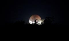 A bride poses for photo during a total lunar eclipse from in Brasilia, Brazil, July 27, 2018. REUTERS/Ueslei Marcelino TPX IMAGES OF THE DAY