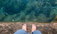 Man standing on a wall overlooking water