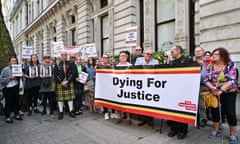 Demonstrators hold a large placard reading 'Dying for justice' outside a building in London