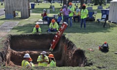 workers excavate a potential mass grave